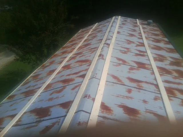Rusted metal roof panels with new wood purlins before replacement — Storm Damage Roof Repair in Underhill by Roofing Brothers