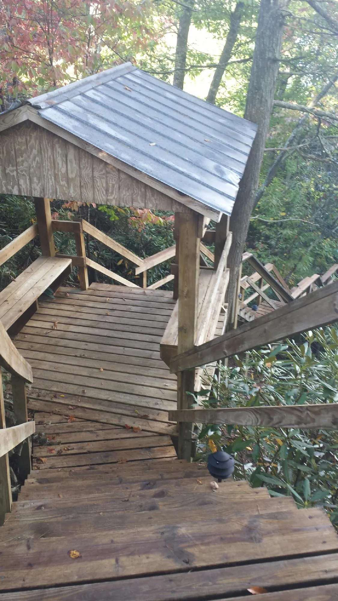 Metal roofed shelter over wooden steps on a wooded walkway — Skylight Repair & Installation work by our crew in Underhill